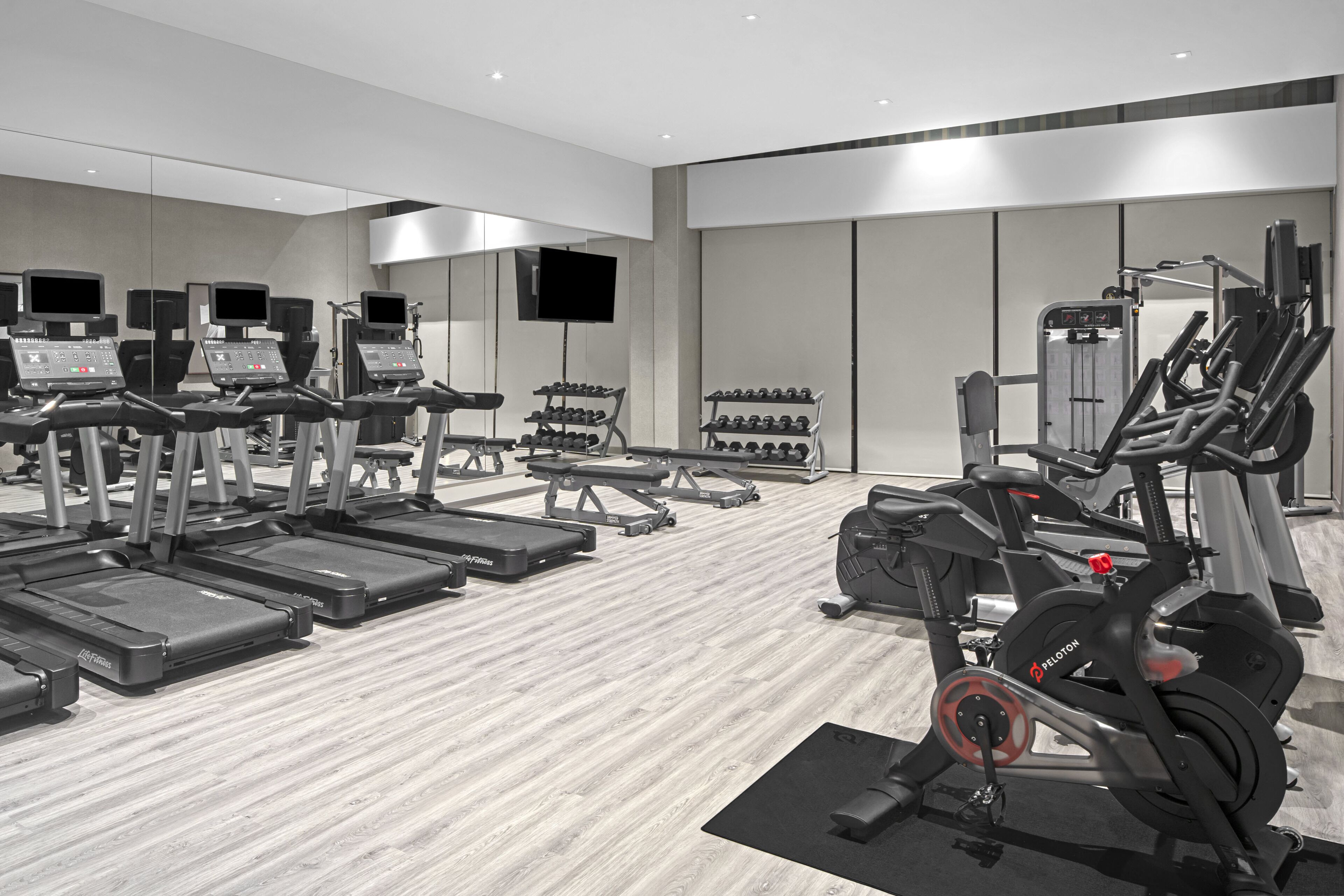 A modern gym with treadmills, elliptical machines, and weight machines.