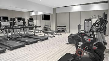 A modern gym with treadmills, elliptical machines, and weight machines.