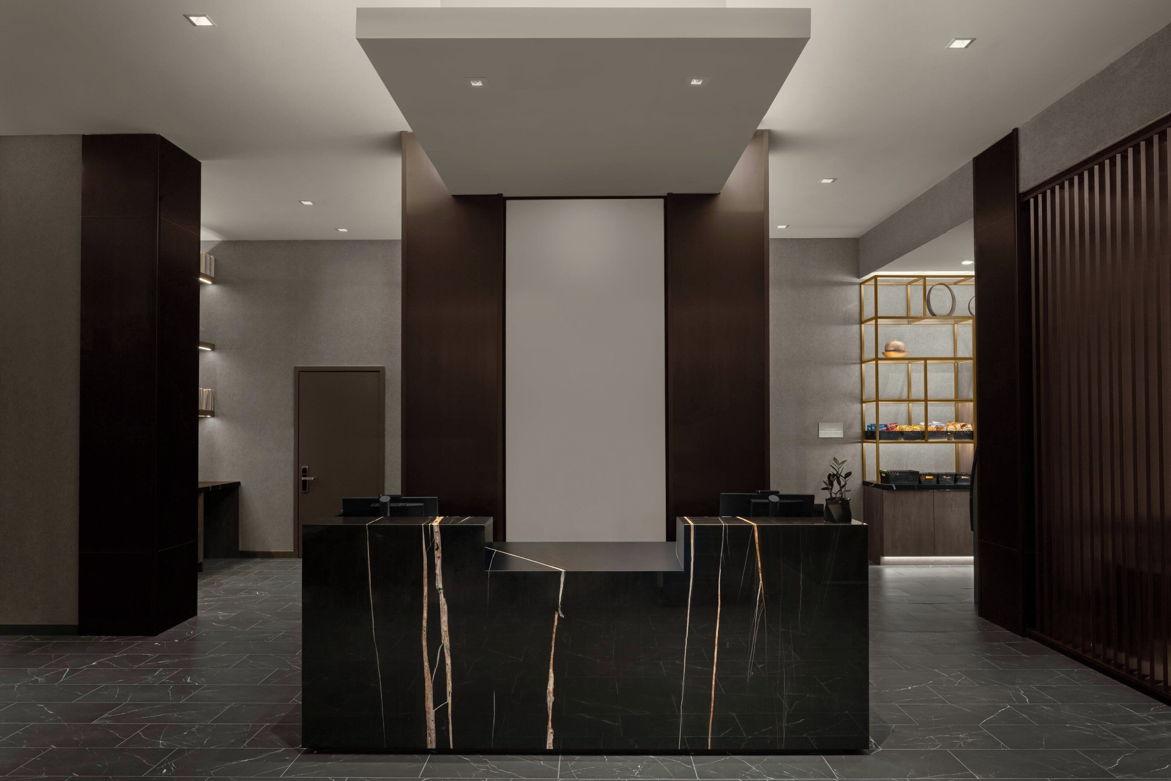 A reception area with a marble reception desk, a wooden panel wall, and a glass display case with items.