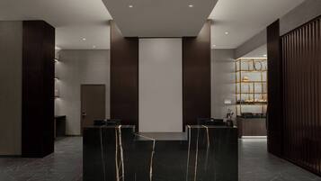 A reception area with a marble reception desk, a wooden panel wall, and a glass display case with items.