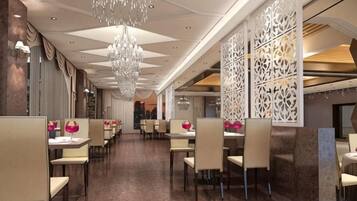 A restaurant with a long counter, multiple tables, and a decorative ceiling.