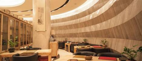 Un intérieur moderne avec un plafond incurvé, des meubles en bois et un pilier central.