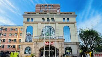 Un edificio con entrada central, ventanas arqueadas grandes y un letrero con caracteres chinos.