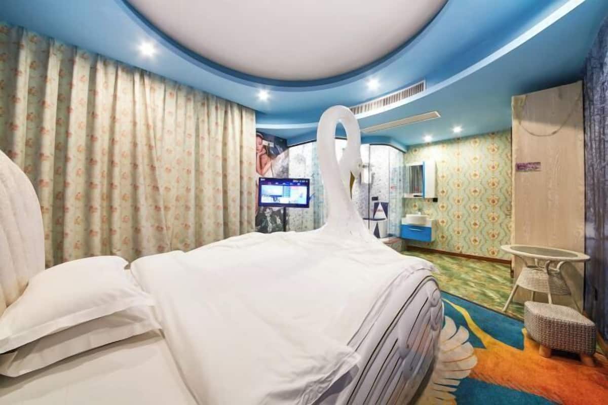 Une chambre d’hôtel avec un lit, une télévision, une salle de bain et une petite table.