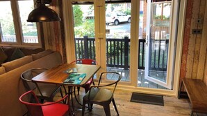 A dining area with a wooden table, red and black chairs, and a black pendant light. - Pet Friendly Lodge - Sleeps 6 (Fordingbridge)