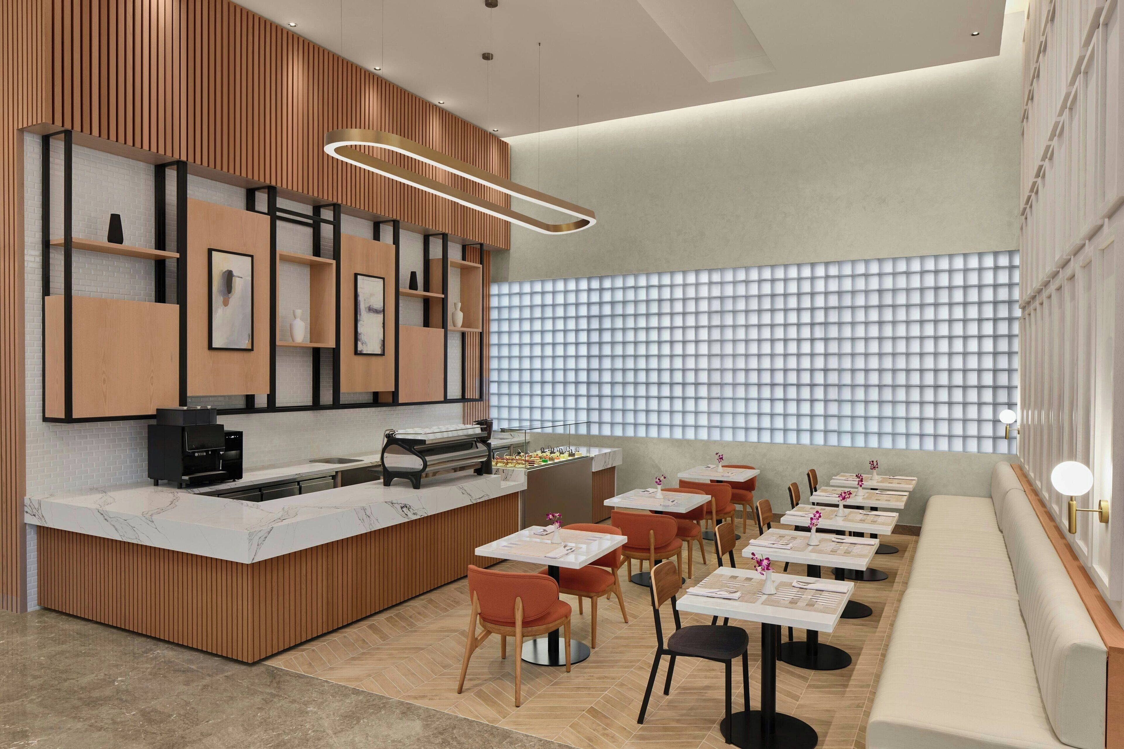 A modern restaurant with a wooden counter, seating area, and a patterned wall.