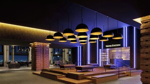 A modern lobby with a water station, seating areas, and a staircase leading to upper floors. - THE OSAKA STATION HOTEL, Autograph Collection (Osaka)
