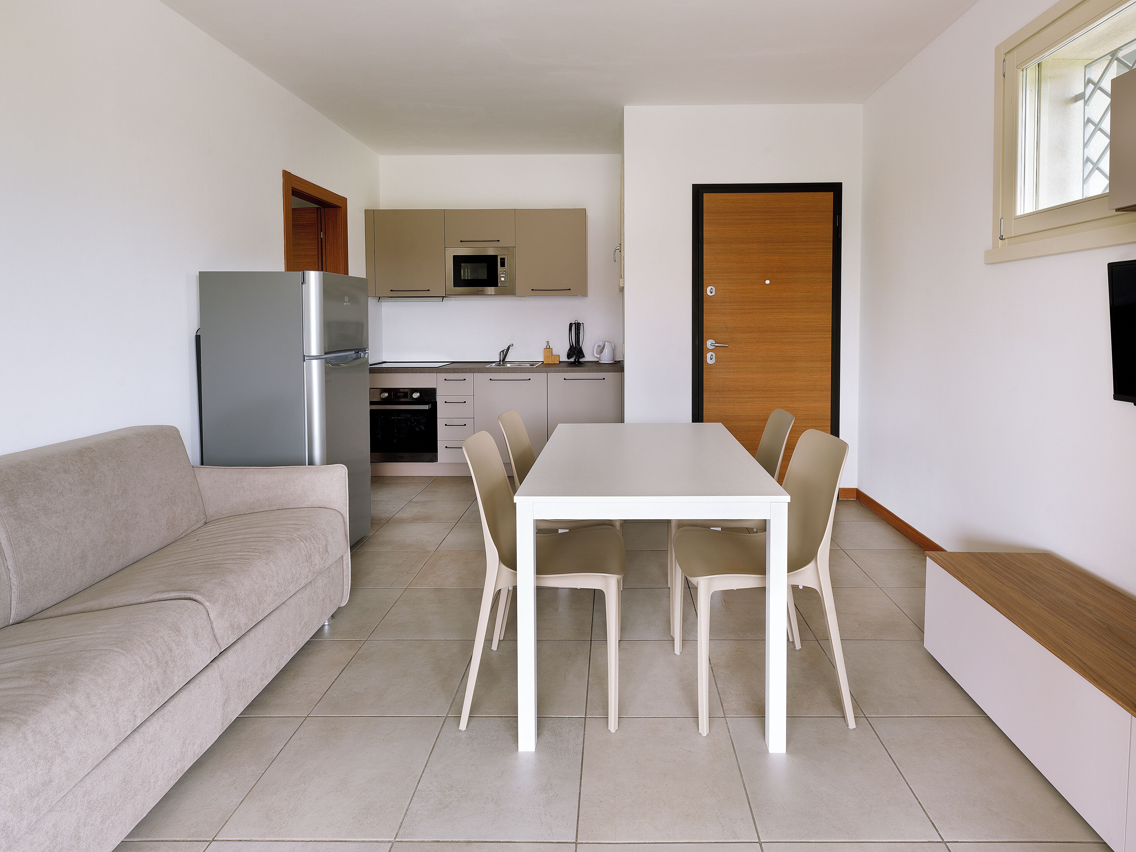 A compact living space with a kitchenette, a dining area, and a sofa.