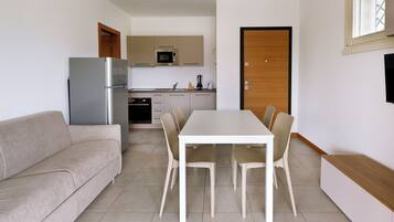 A compact living space with a kitchenette, a dining area, and a sofa.