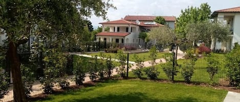 A residential area with a well-maintained lawn, a pathway, and a fence.