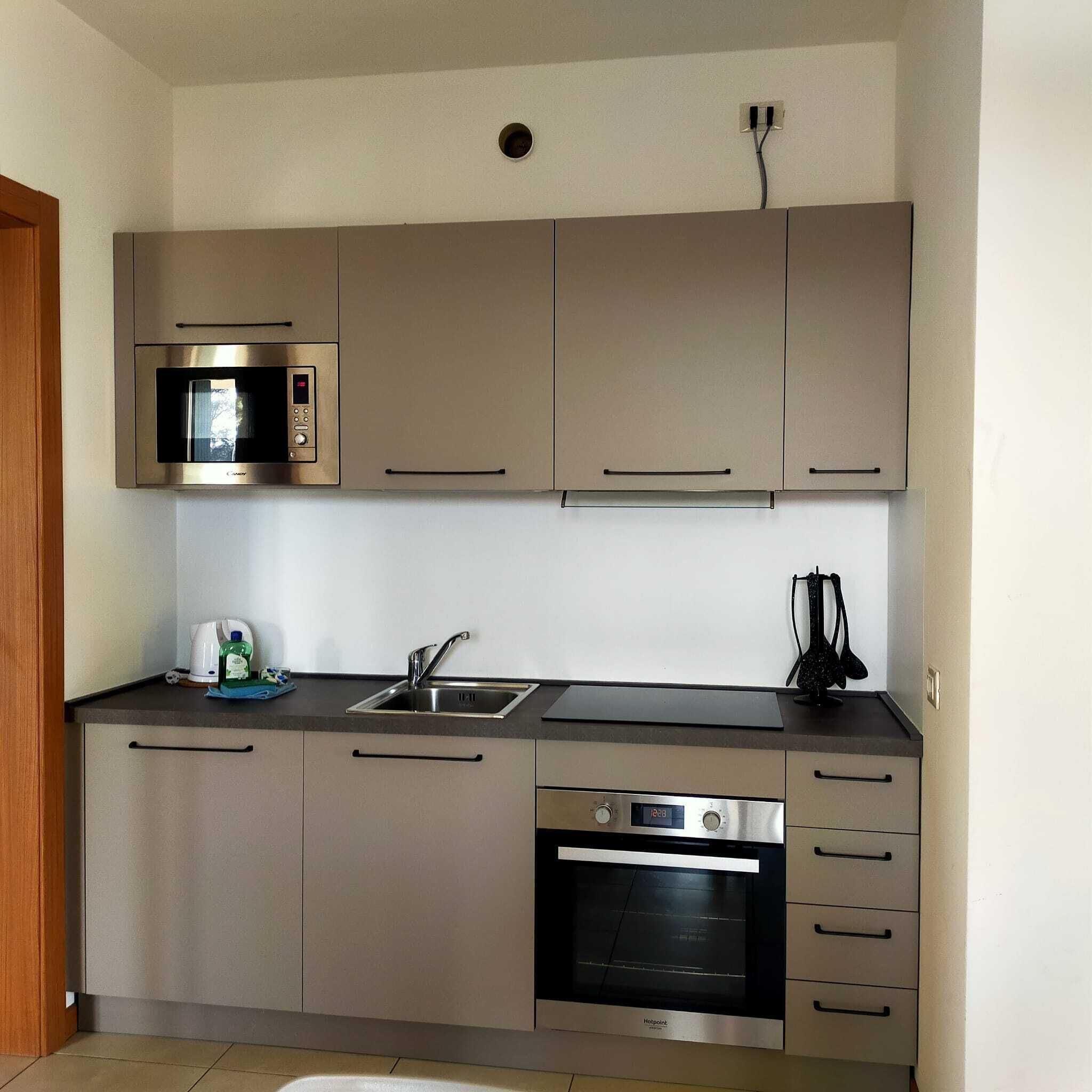 Eine moderne Küche mit Einbau-Mikrowelle, Backofen und Spüle.