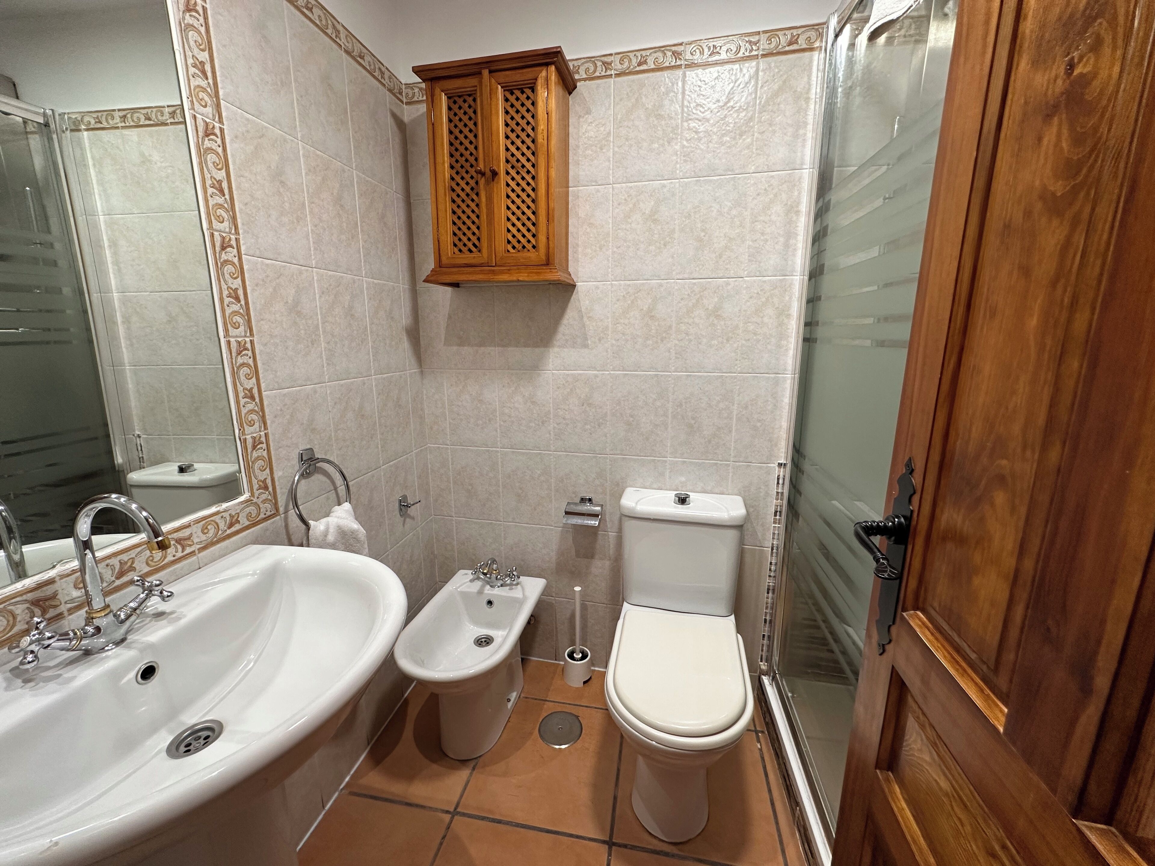 Een badkamer met een wastafel, toilet en een kastje.