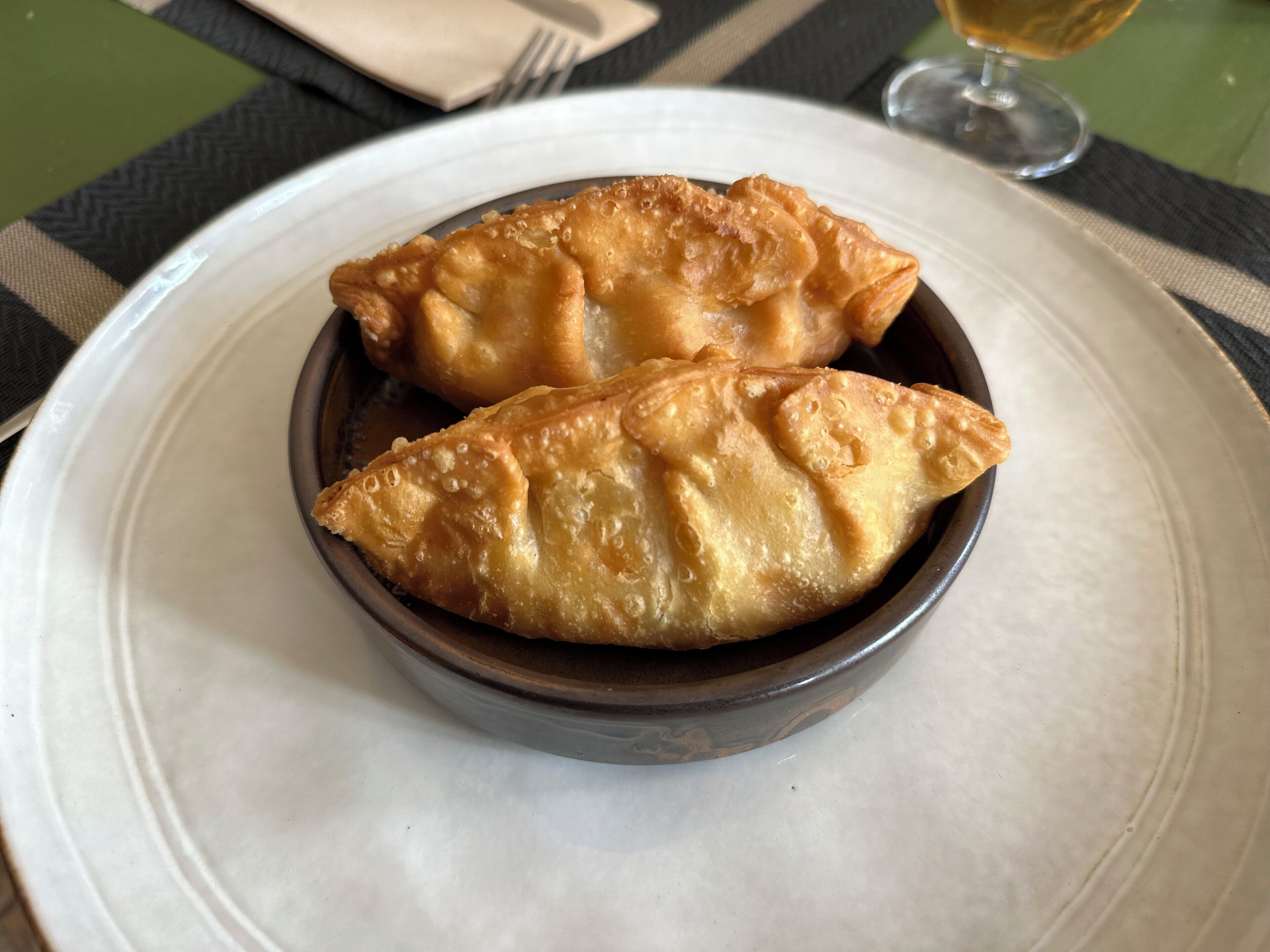 A plate with two golden-brown pastries on a white plate.