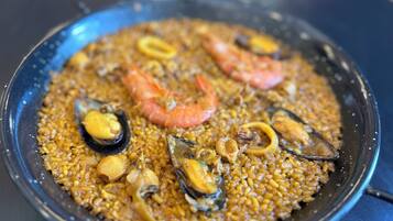 A close-up of a seafood paella with shrimp and mussels.