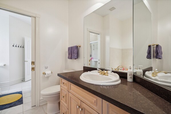 A bathroom with two sinks, a toilet, and a large mirror.