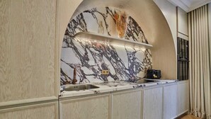 A modern kitchen with a marble backsplash, built-in cabinets, and a stainless steel sink. - Apartment in the Marais with Air-conditioned (Paris)