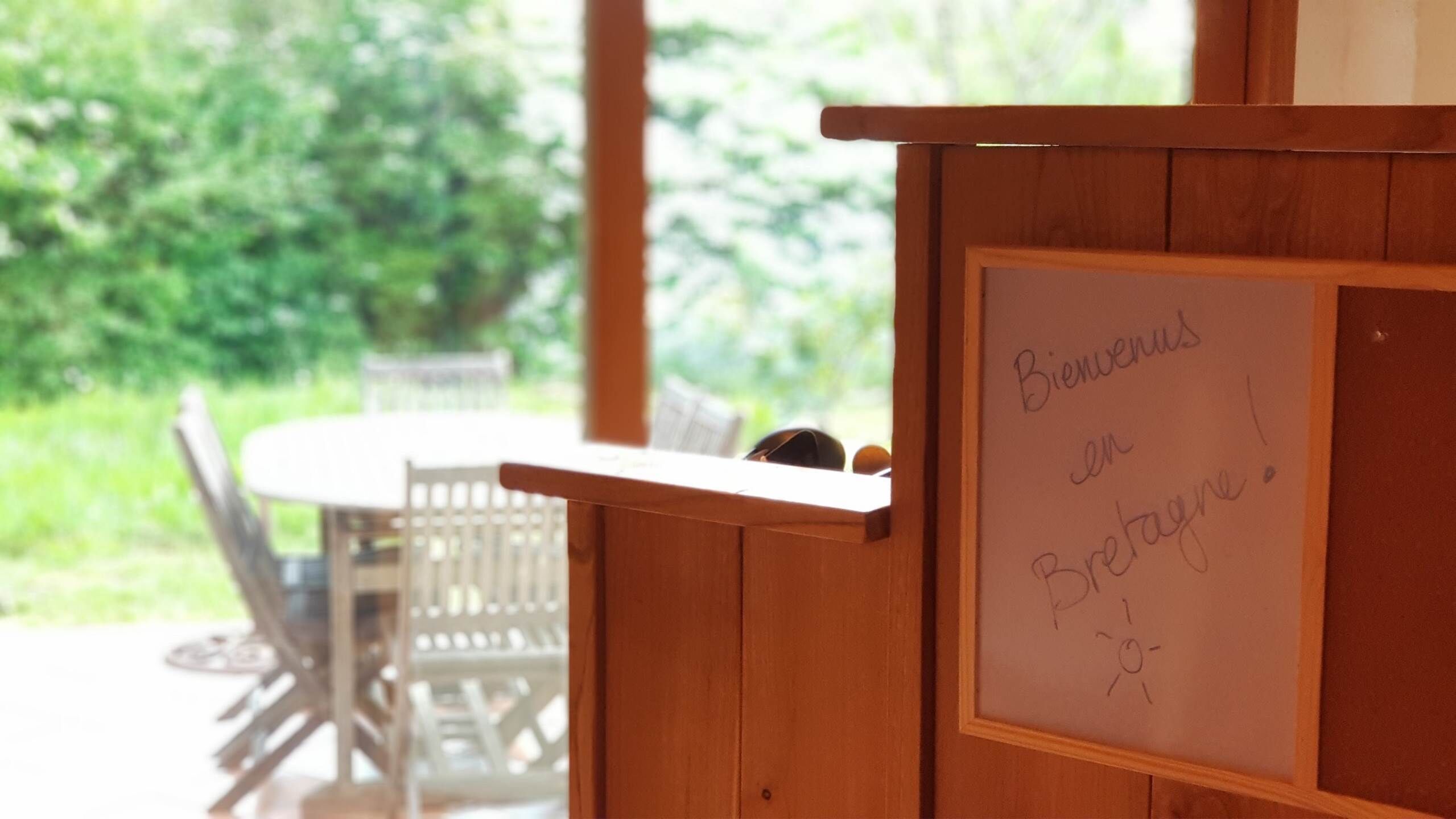 Un mostrador de recepción de madera con un letrero de bienvenida escrito a mano en francés.