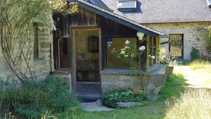 A rustic stone building with a wooden door and a small porch.