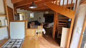 A compact kitchen with a gas stove, wooden chairs, and a dining table.