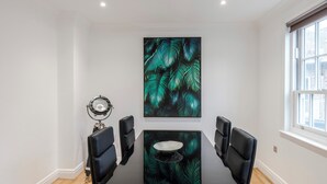 A conference room with a whiteboard, a globe, and a table with chairs. - Closetoharrods - Closetohydepark - 2 bed House (London)