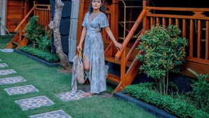 A wooden building with a staircase and a tree in the foreground. - Villa Mayu (Karangasem)