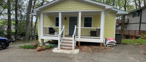 A small, single-story house with a front porch and a covered driveway.