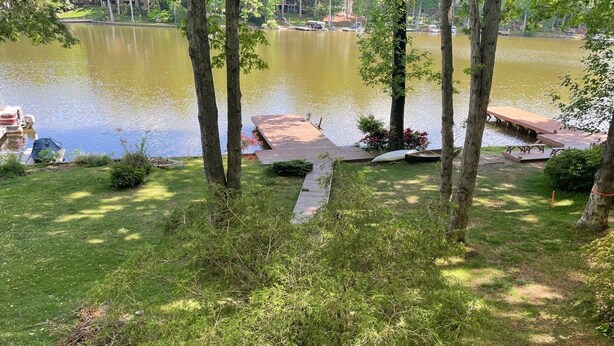A lakeside view with picnic tables and a dock. - Newly Renovated Lakefront Home with Kayaks and Paddleboards (Locust Grove)