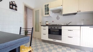 A kitchen with white cabinets, a black countertop, and a checkered floor. - Casa Albachiara a 500 Metri Dalla Spiaggia (Lavagna)