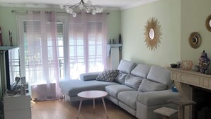 A living room with a grey sectional sofa, a round coffee table, and a cat tree. - Spacious and modern 4 bedroom 2 bathroom House with garden ideal fir families  (Villejuif)
