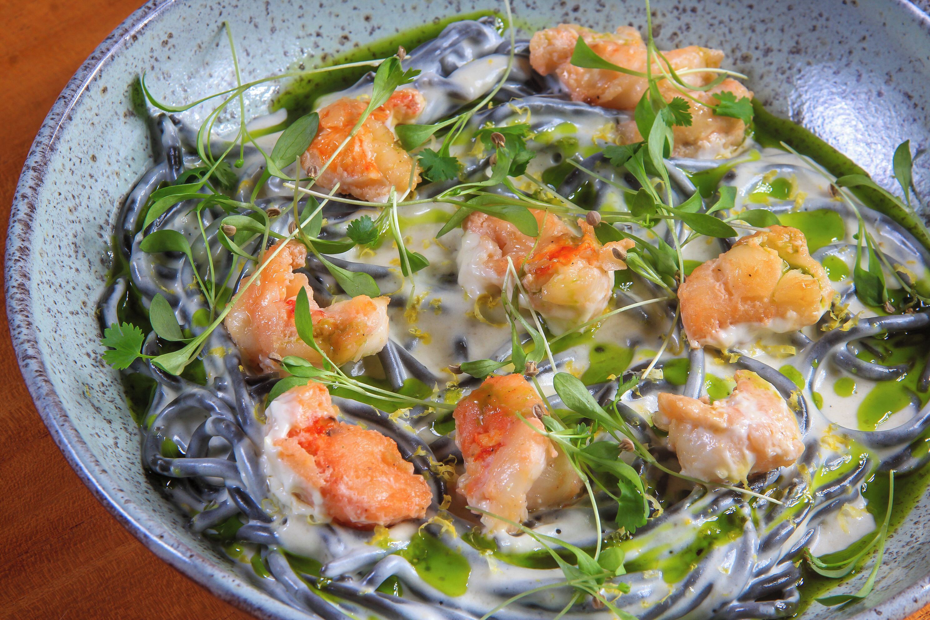 Un bol de nouilles aux crevettes et aux légumes verts.