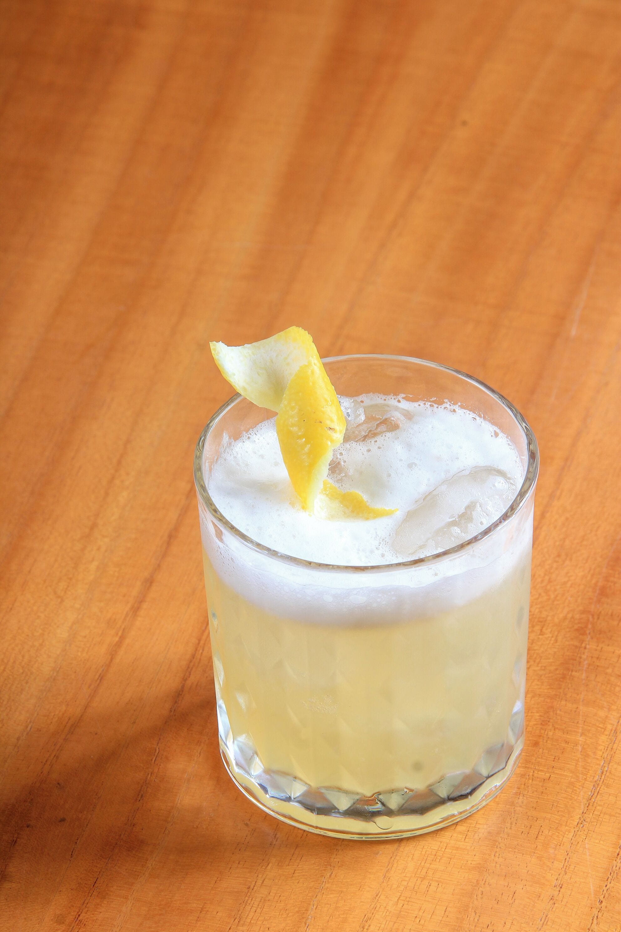 Un verre orné d’une garniture jaune, posé sur une surface en bois.