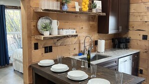 Une cuisine moderne dotée de meubles en bois, d’un îlot central avec des tabourets de bar et de divers appareils de cuisine.