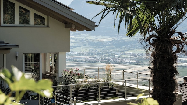 A modern house with a balcony overlooking a scenic landscape.