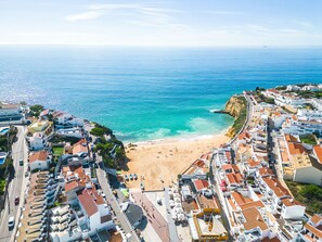 A coastal town with a beach, white buildings, and a clear view of the sea.
