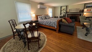 A bedroom with a bed, a desk, and a chair. There is a fireplace and a window with blinds. - Big Dam Room right off VA Creeper Trail Damascus (Damascus)