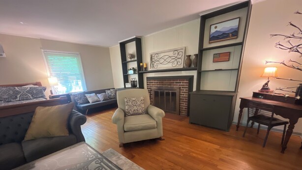 A living room with a sofa, armchair, coffee table, fireplace, and a desk with a lamp. - Big Dam Room right off VA Creeper Trail Damascus (Damascus)