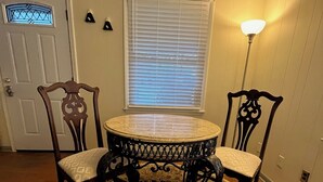 A dining area with a round table, two chairs, a patterned rug, a window with blinds, and a door. - Big Dam Room right off VA Creeper Trail Damascus (Damascus)