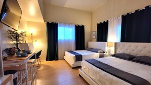 A hotel room with a desk, two beds, a chair, and a potted plant. - Spacious studio near Beverlywood. 5 minutes to Rodeo Drive!  (Beverly Hills)