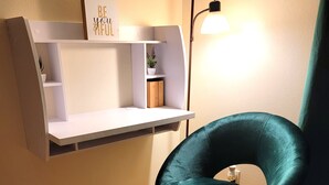 A room with a teal chair, a white shelf unit with a motivational sign, a floor lamp, and a wooden floor. - Spacious studio near Beverlywood. 5 minutes to Rodeo Drive!  (Beverly Hills)