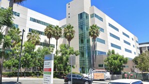 A modern building with a glass facade, surrounded by palm trees and a clear blue sky. - Spacious studio near Beverlywood. 5 minutes to Rodeo Drive!  (Beverly Hills)