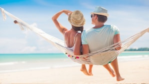 Un couple se détend dans un hamac sur une plage.