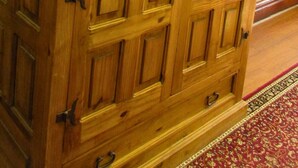 A wooden cabinet with multiple doors and drawers, featuring a classic design with metal handles and hinges. - The Stone room Suite #11, sleeps 5 guest (Hot Springs)