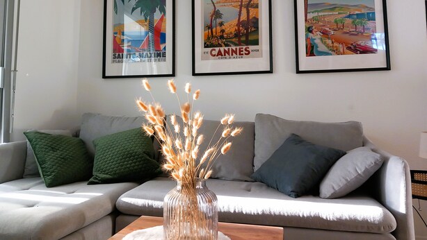 A living room with a sofa, a vase with dried flowers, and three framed posters on the wall. - Appartment (2 rooms / 4 persons) with terrasse and swimminpool (Fréjus)