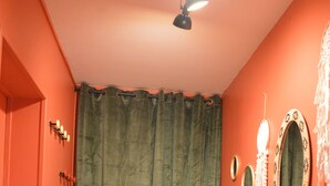 A room with a green curtain, a mirror, and a door with a light fixture. - Gîte La Rose Trémière - Maison Avec Terrasse, Idéale Pour un Séjour en Famille (Joinville)
