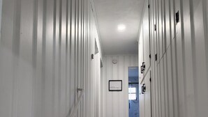 A narrow, white-paneled hallway with a wooden staircase leading to a door at the end. - Beautiful Mid Term Home in the Elegance of Winter Park!

 (Winter Park)