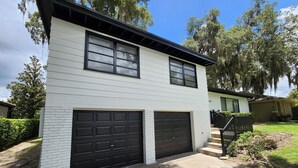 A two-story house with a garage, a front porch, and a well-maintained lawn. - Beautiful Mid Term Home in the Elegance of Winter Park!

 (Winter Park)