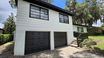 A two-story house with a garage, a front porch, and a well-maintained lawn.