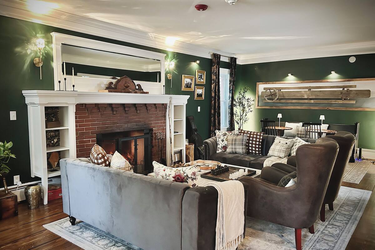 A cozy living room with a fireplace, a sofa, armchairs, and a coffee table.