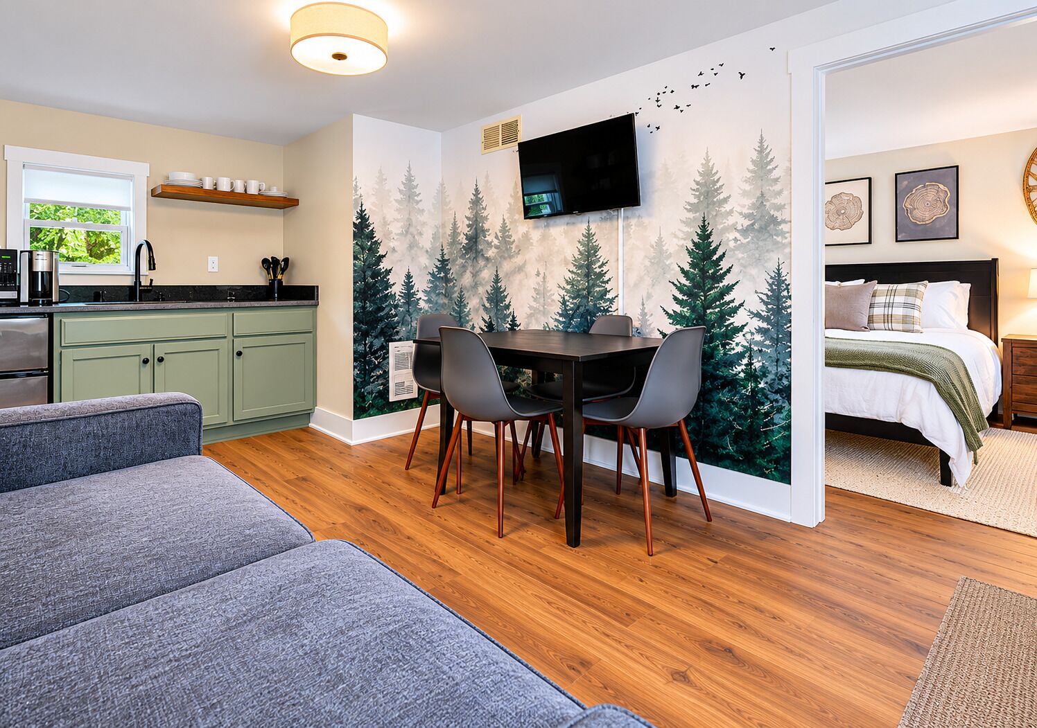 Een knus verblijf met een eethoek, kitchenette en een bed.