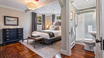 Une chambre à coucher avec un lit, une commode et une vue sur la salle de bain.